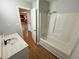 Bathroom with bathtub and shower head with a white vanity top and wood-look flooring at 774 Mill Rd, Mcdonough, GA 30253