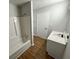Bathroom with a white shower/tub, vanity, and wood-look floors, offering a modern and functional space at 774 Mill Rd, Mcdonough, GA 30253