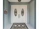 Elegant double front doors with decorative glass inserts and a stylish welcome mat on a cozy porch at 900 Stone Lea Trce, Oxford, GA 30054