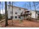 Back of house with outdoor deck, stairs, concrete patio, and wooded scenery at 1810 Valley Brook Dr, Alpharetta, GA 30005