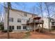 Two-story back of house with deck, stairs, concrete patio, and trees at 1810 Valley Brook Dr, Alpharetta, GA 30005