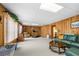 Finished basement with wood paneling, a green leather couch, and a treadmill at 1810 Valley Brook Dr, Alpharetta, GA 30005