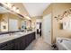 Large bathroom with double sinks, dark wood cabinetry, granite counters, and separate tub and shower at 1810 Valley Brook Dr, Alpharetta, GA 30005