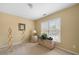 Neutral bedroom featuring a window overlooking a yard, a side table, and a lamp at 1810 Valley Brook Dr, Alpharetta, GA 30005