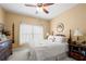 Cozy bedroom with natural light, featuring a bed with soft white bedding, ceiling fan and classic furniture at 1810 Valley Brook Dr, Alpharetta, GA 30005