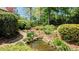 Lush backyard featuring an idyllic pond with rock features and landscaping at 204 Overland Trl, Mcdonough, GA 30252