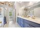 Bathroom with dual sinks, a bathtub, a separate shower, and blue cabinets at 204 Overland Trl, Mcdonough, GA 30252