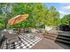 Outdoor deck features seating, umbrellas, black and white rug, and stairs down to the yard at 204 Overland Trl, Mcdonough, GA 30252