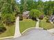 Charming brick home with lush landscaping, long driveways, and mature trees at 204 Overland Trl, Mcdonough, GA 30252