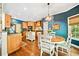A well-lit kitchen and eat-in dining area with an island, wooden cabinets and floors at 204 Overland Trl, Mcdonough, GA 30252
