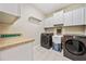 Well-organized laundry room featuring modern washer and dryer, cabinetry, and utility sink at 204 Overland Trl, Mcdonough, GA 30252