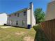 View of the backyard of a two-story home featuring a lawn, a fence, and some trees on a sunny day at 2752 Live Oak Trl, Atlanta, GA 30349
