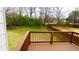Wooden deck overlooks a spacious, fenced backyard with lush green grass and mature trees at 3094 Jonesboro St, Ellenwood, GA 30294