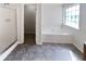 Relaxing bathroom with a tub, tile floors, and a bright window at 6028 Arbor Links Rd, Lithonia, GA 30058