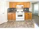 Well lit kitchen with wood cabinets, appliances, and gray countertops at 6028 Arbor Links Rd, Lithonia, GA 30058