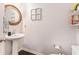 Stylish powder room features pedestal sink, round mirror and classic fixtures at 38 Trailview Ln, Hiram, GA 30141