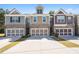 Three modern townhomes, each with two-car garages and distinct color schemes, line a spacious driveway at 38 Trailview Ln, Hiram, GA 30141