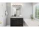Bathroom featuring a dark vanity cabinet, granite countertop, bathtub and natural light from a window at 384 Wesley Dr, Acworth, GA 30101