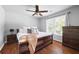 A primary bedroom features hardwood floors, ceiling fan, large window and dresser at 384 Wesley Dr, Acworth, GA 30101