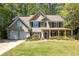 Charming two-story home with manicured lawn, two-car garage, and welcoming front porch with columns at 384 Wesley Dr, Acworth, GA 30101