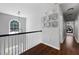 Hallway with wood floors, white railing and window, and decoratively hung framed photos at 384 Wesley Dr, Acworth, GA 30101