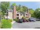 A tan building with a brick chimney and multiple balconies, surrounded by green trees and a parking lot in front at 5566 River Heights Se Xing, Marietta, GA 30067