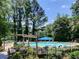 Community pool surrounded by trees and chairs at 5566 River Heights Se Xing, Marietta, GA 30067
