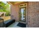 Inviting front porch with brick facade and stylish black bench at 6150 Thorncrest Dr, Tucker, GA 30084