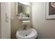 Stylish powder room with a pedestal sink, modern fixtures, and elegant decor at 6150 Thorncrest Dr, Tucker, GA 30084