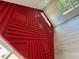 Close up of decorative, geometric, red accent wall with window and hardwood floors at 1331 E Atlanta E Rd, Stockbridge, GA 30281