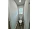 Small bathroom with a toilet, small window, and wood-look floors at 1331 E Atlanta E Rd, Stockbridge, GA 30281