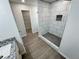 Bathroom featuring a shower stall with gray and white tiling and gold hardware at 1331 E Atlanta E Rd, Stockbridge, GA 30281