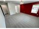 Bright bedroom with textured red accent wall, plush gray carpet, and bright windows at 1331 E Atlanta E Rd, Stockbridge, GA 30281