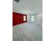 A bright bedroom features a textured red accent wall and plush gray carpeting at 1331 E Atlanta E Rd, Stockbridge, GA 30281