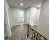 Upstairs hallway leading to bathroom with wood handrail and black iron balusters at 1331 E Atlanta E Rd, Stockbridge, GA 30281