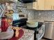 Up close shot of stove in kitchen with blacksplash and bronze hardware at 1331 E Atlanta E Rd, Stockbridge, GA 30281