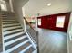 Bright living room with modern floors, open stairs, vibrant accent wall and ample natural light at 1331 E Atlanta E Rd, Stockbridge, GA 30281