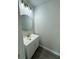 Powder room featuring a white vanity, round mirror, and modern lighting at 1331 E Atlanta E Rd, Stockbridge, GA 30281
