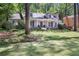 Charming single-story home with a manicured lawn and inviting blue front door at 2567 Hyde Manor Nw Dr, Atlanta, GA 30327