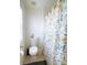 Bathroom featuring a toilet, a patterned shower curtain, and a window for natural light at 385 Bethesda Park Trl, Lawrenceville, GA 30044