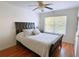 Cozy bedroom with a ceiling fan, hardwood floors, and natural light streaming through the window at 385 Bethesda Park Trl, Lawrenceville, GA 30044