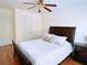 Bright bedroom featuring a ceiling fan, hardwood floors, and a comfortable queen-size bed with stylish bedding at 385 Bethesda Park Trl, Lawrenceville, GA 30044