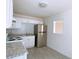 Kitchen features white cabinets, stainless refrigerator, and granite countertops at 385 Bethesda Park Trl, Lawrenceville, GA 30044