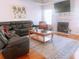 Living room features hardwood floors, fireplace, and large black sectional couch at 385 Bethesda Park Trl, Lawrenceville, GA 30044