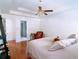 Bright main bedroom featuring tray ceilings, hardwood floors, and a ceiling fan at 385 Bethesda Park Trl, Lawrenceville, GA 30044