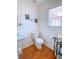 Powder room with pedestal sink, framed art, and hardwood floors at 385 Bethesda Park Trl, Lawrenceville, GA 30044