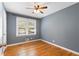 Comfortable bedroom featuring hardwood floors, a window with blinds, and ample natural light at 4462 Cain Cir, Tucker, GA 30084