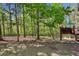 Backyard featuring a deck, bordered by lush trees and a quaint wooden fence at 5876 Bridgemont Nw Pl, Acworth, GA 30101