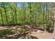 Backyard view with lush green trees, wooden fence in background and ample space at 5876 Bridgemont Nw Pl, Acworth, GA 30101