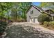 Wide driveway leading to a two-car garage, surrounded by lush landscaping and trees at 5876 Bridgemont Nw Pl, Acworth, GA 30101